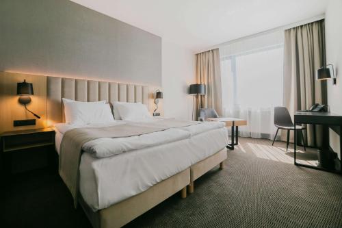 een hotelkamer met een groot bed en een raam bij V Hotel Warsaw in Warschau