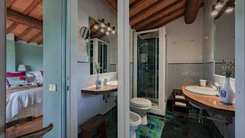 a bathroom with a sink and a toilet and a bed at Salve Regina in Impruneta
