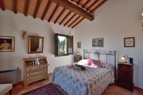 a bedroom with a bed and a wooden dresser at Il Balcone in Gaiole in Chianti