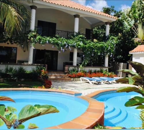 a swimming pool in front of a house at Villa Metro Country Club in Juan Dolio