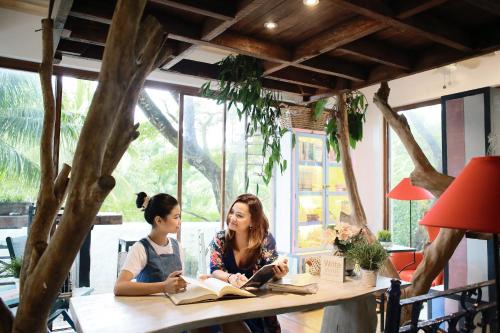 two women sitting at a table reading books at La Bella Boutique Hotel in Tagaytay