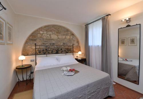 um quarto com uma cama grande e um espelho em Athena em Castellina in Chianti