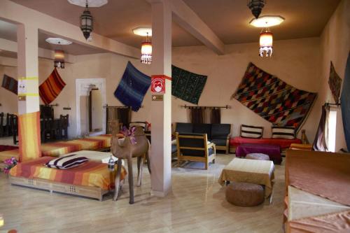 a room with beds and furniture in a room at Auberge La Source in Merzouga