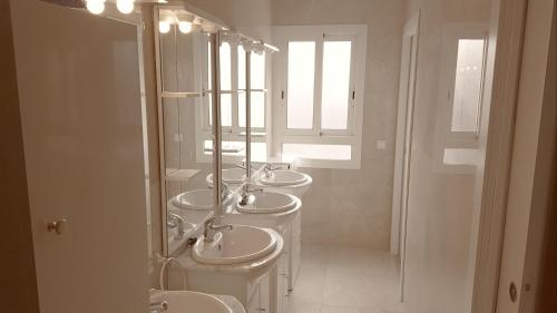 a bathroom with four sinks and a row of mirrors at Hostel Penedes in Vilafranca del Penedès
