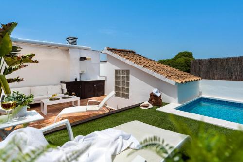 une arrière-cour avec une piscine et une maison dans l'établissement AlohaMundi San Luis, à Séville