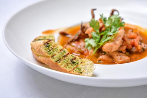 a white bowl of food with meat and vegetables at Nairobi Safari Club by Swiss-Belhotel in Nairobi