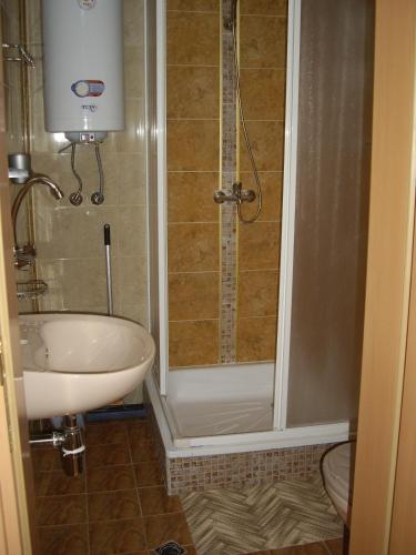 a bathroom with a shower and a sink and a toilet at Guest House Rusalka in Shipkovo