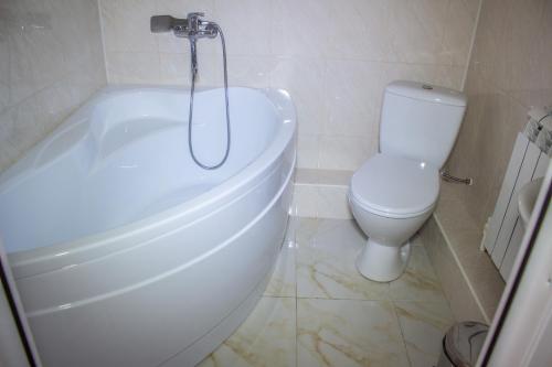 a bathroom with a white tub and a toilet at Chayka Hotel Ingushetia in Armkhi