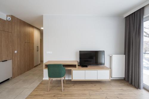 a living room with a desk and a television at Marina Apartments ZOO in Wrocław