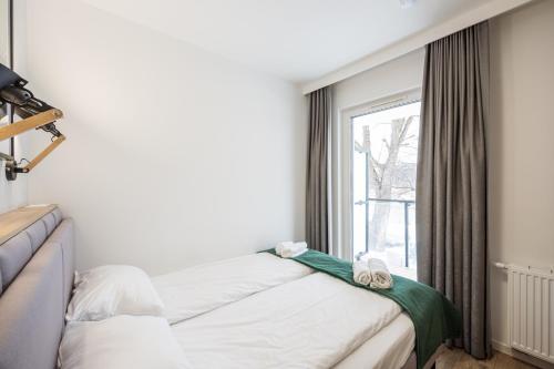 a bedroom with a bed and a window at Marina Apartments ZOO in Wrocław