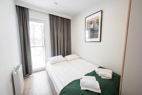 a bedroom with a bed with two pillows on it at Marina Apartments ZOO in Wrocław