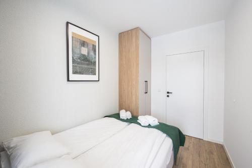 a bedroom with a bed with two towels on it at Marina Apartments ZOO in Wrocław