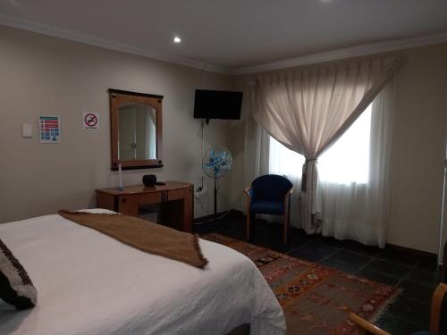 a bedroom with a bed and a mirror and a window at Troas Boutique hotel in Vanderbijlpark