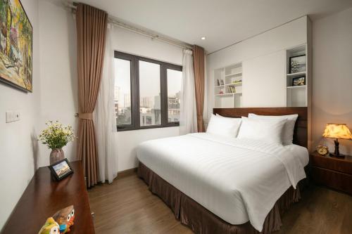 سرير أو أسرّة في غرفة في Poonsa Duy Tan Hotel and Serviced Apartment