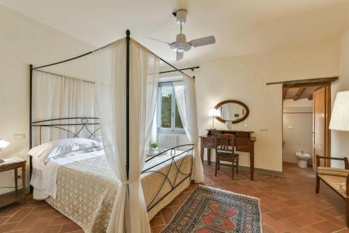 a bedroom with a canopy bed and a desk at Lo Scarpellino in Bucine