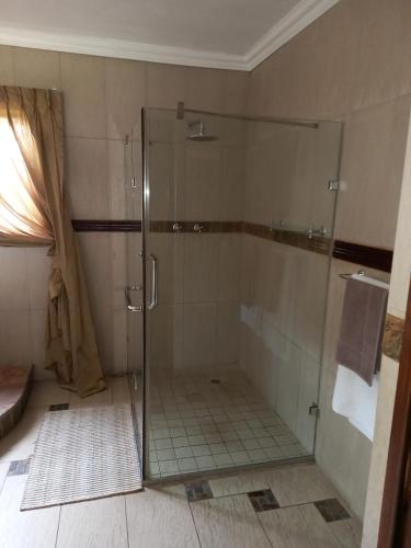 a shower with a glass door in a bathroom at Troas Boutique hotel in Vanderbijlpark
