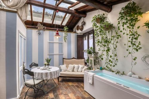 a living room with a tub and a table with plants at B&B dei Papi Boutique Hotel in Viterbo
