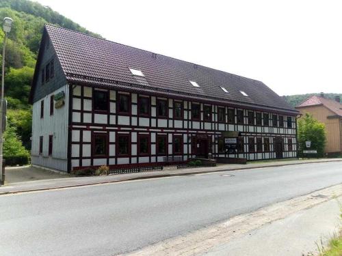 a black and white building on the side of a road at Haus am Wolfsbach Gruppenunterkunft in Zorge