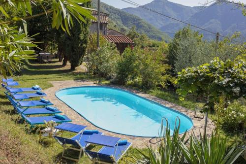 a swimming pool with blue lounge chairs and a swimming pool at Casa Tognarello in Borgo a Mozzano