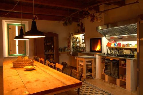 a kitchen with a wooden table and a dining room at BORGO PETELIA, Casa Centro, Antica abitazione calabrese con giardino, ristrutturata in Strongoli