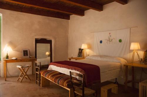 a bedroom with a bed and a table and a mirror at BORGO PETELIA, Casa Centro, Antica abitazione calabrese con giardino, ristrutturata in Strongoli