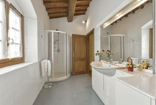 a white bathroom with two sinks and a shower at Villa di Capannole 12 in Bucine