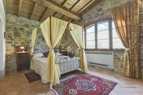 a bedroom with a canopy bed in a stone room at Villa di Capannole 12 in Bucine