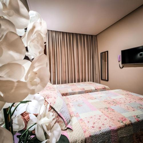 a bedroom with a bed with white flowers next to it at Terra dos Diamantes Hotel in Lençóis