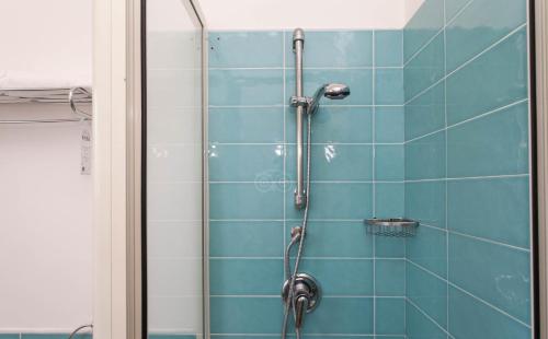 a shower in a bathroom with blue tiles at Club Esse Sunbeach in Squillace