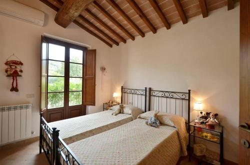 Un dormitorio con una cama y una ventana grande. en Casa Maria, en Castelnuovo Berardenga