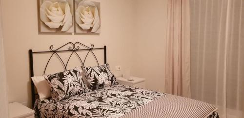 una camera da letto con un letto con un piumone bianco e nero di NEPTUNO 2B MENYBER a Nerja