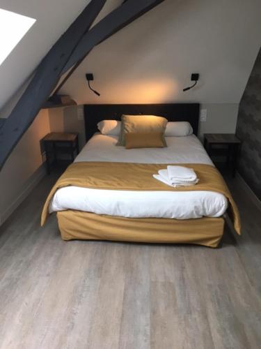 a bedroom with a large bed in a attic at Le Relais in Saint-Quentin-les-Anges