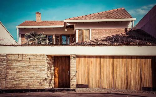 a brick house with a wooden garage at Open House Hostel in Mendoza