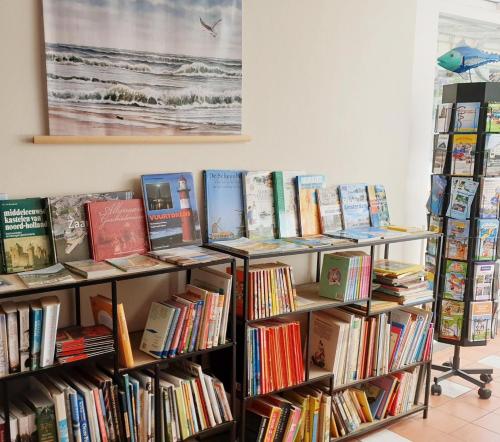 a row of shelves filled with books at Zeelui in Egmond aan Zee