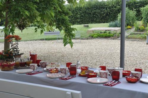 Una mesa blanca con platos de comida encima. en La Ferme Blanche, en Cussay