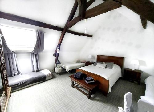 a room with a bedroom with a bed and a table at La Bretonnière, Longère Picarde in Passel