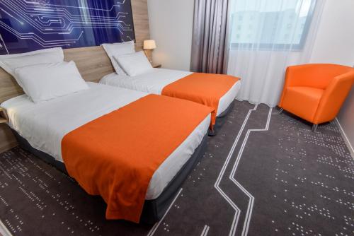Ένα ή περισσότερα κρεβάτια σε δωμάτιο στο Mercure Poitiers Site du Futuroscope