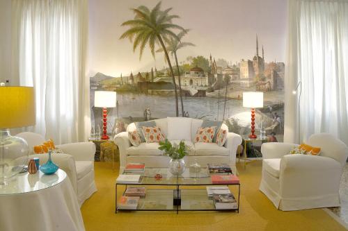 a living room with white furniture and a palm tree mural at Palazzo Ca'nova on the Grand Canal - Canella Apartment in Venice