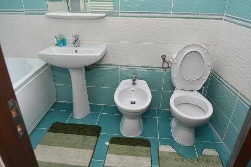 een badkamer met een wastafel, een toilet en een bidet bij Hotel GeAS IV in Caransebeş