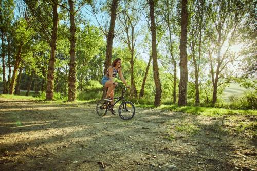 a woman riding a bike down a dirt road at Agriturismo Lunadoro in Monticchiello