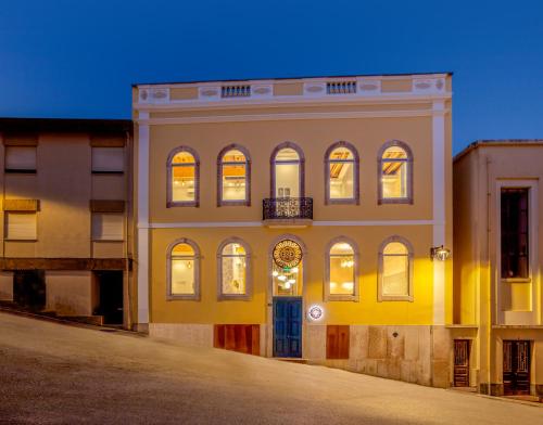 un edificio amarillo con un cielo azul en el fondo en Bacharéis Charming House en Figueira da Foz