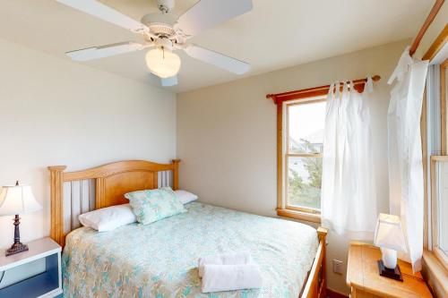 a bedroom with a bed with a ceiling fan and a window at Enduring Freedom #6-8 in Avon