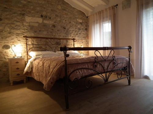 Un dormitorio con una cama y una pared de piedra. en Agriturismo Vidalli Colvidor, en Vidor