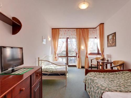 a hotel room with two beds and a tv and a bedroom at Willa Focus in Mielno