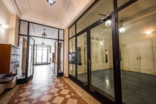 a hallway with glass doors in a building at LE SEQUOIA Appart' pour 4 au Cœur de ville VICHY in Vichy