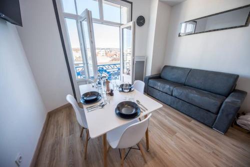 un salon avec une table blanche et un canapé dans l'établissement LE SEQUOIA Appart' pour 4 au Cœur de ville VICHY, à Vichy