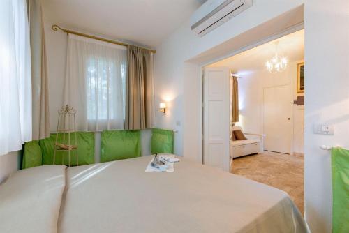 um quarto com uma cama com uma cabeceira verde em Iris em Castagneto Carducci