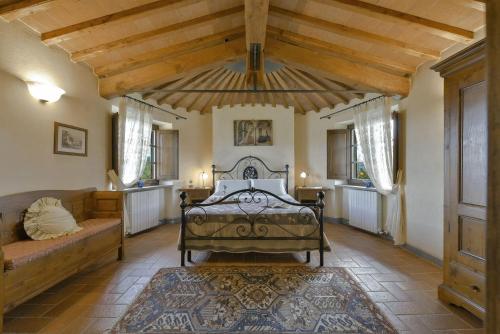 Un dormitorio con una cama y un sofá en una habitación. en Poggio della Villa, en Radda in Chianti
