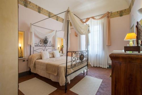 a bedroom with a four poster bed with a canopy at Villa Angelica in Peccioli