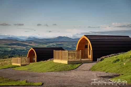 a couple of buildings on top of a hill at Schiehallion Luxury Glamping Pod with Hot Tub at Pitilie Pods in Aberfeldy